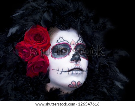Close-up portrait shot of a woman in scary sugar skull make-up and fur with roses.