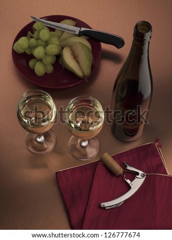Wine set consist of white wine, bottle opener and fruits