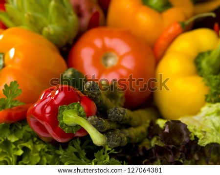 A red pepper as the focal point among many other vegetables.