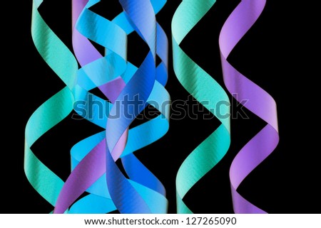 Close-up shot of colorful spiral streamers on plain dark background.