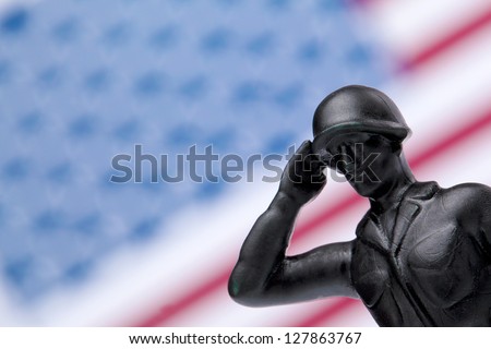 Military Soldier saluting and giving honor on American flag