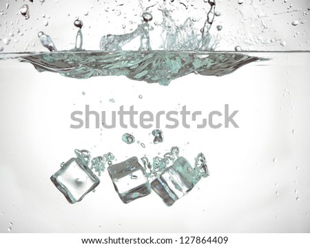 Ice cubes dropped in to the water slowly sinking