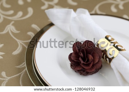 Gold napkin ring and flower decoration in a seamless background