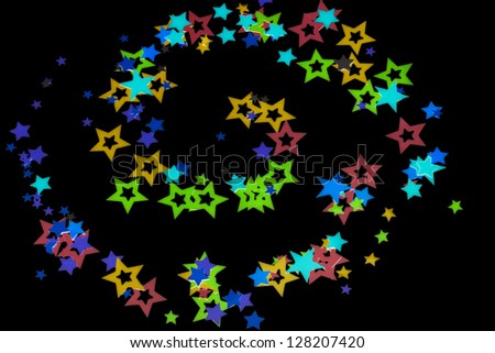 Close-up shot of colorful stars on plain black background.