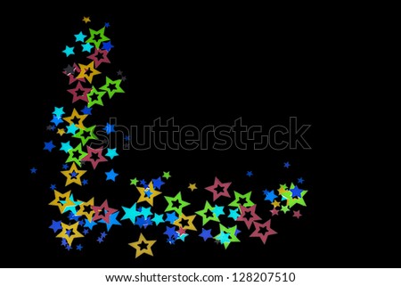 Close-up shot of colorful decorative star shapes over plain dark background.