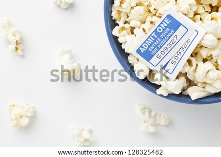Cropped image of bowl of popcorn with movie ticket with scattered popcorn