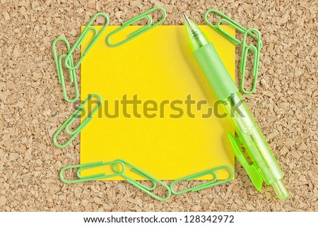 Close-up image of adhesive paper, green clip and pen