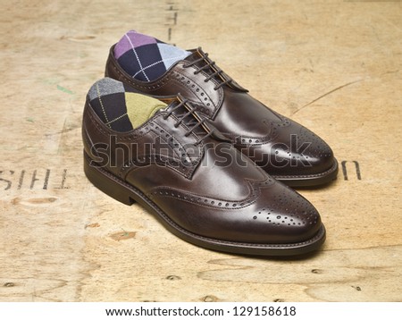 Pair of brown leather shoes over a wooden background