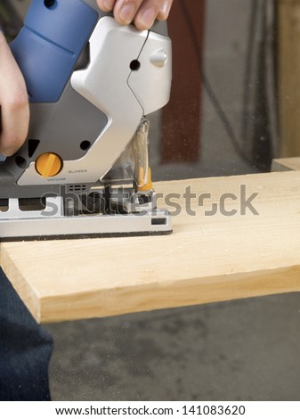 Close up image of cutting a wood using jigsaw cutter