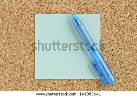 Close-up image of a blue ballpen and adhesive paper