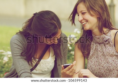 Two Girl While They Make a Speak a Phone