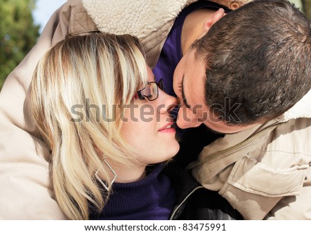 Couple in love, outdoor shot of two young people, woman and man kissing.