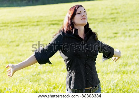Joy of life, woman with outstretched arms. Sunny outdoor shot.