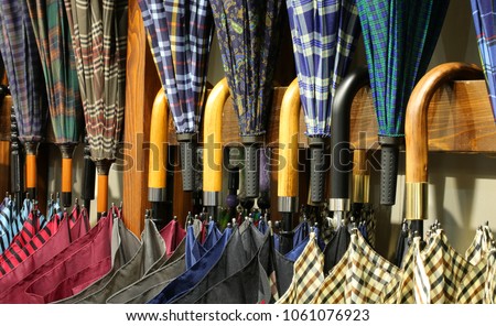 many umbrellas with wooden handles for sale in the shop specializing in fashion accessories