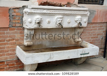 ancient marble fountain with a white tub under