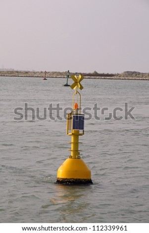 Yellow signalling buoy in the middle of the sea to help boats