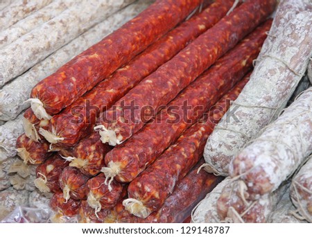 bunch of Salamis and spicy sausages with garlic for sale at the local market in Italy