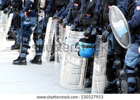 policemen in riot gear with shields and helmets and helmets during the urban riots