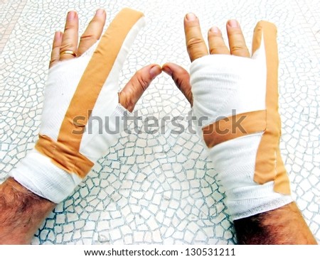 two hands breaking of bones wrapped in bandages