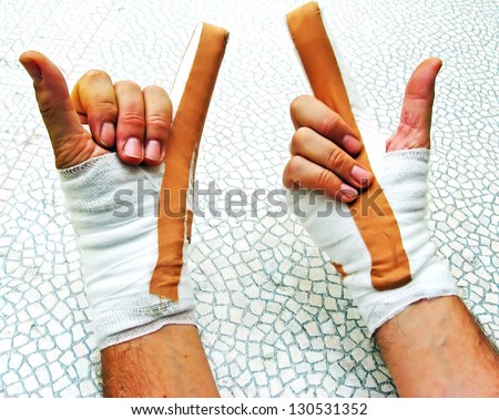 hands breaking of bones wrapped in bandages and plasters