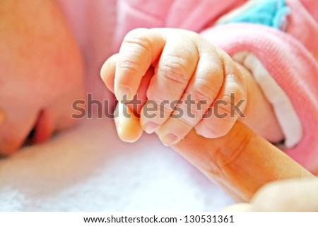 little baby shakes hands with his finger to his father