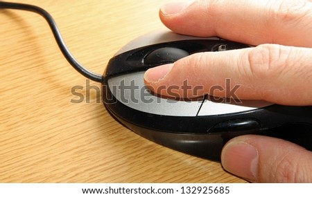 hand of a young adult who click the left mouse button with the index