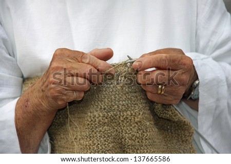 hands of an elderly woman during the processing of wool sweater
