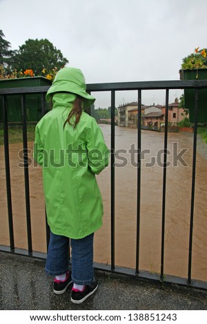 young girl with waterproof watch with dismay the growing river level