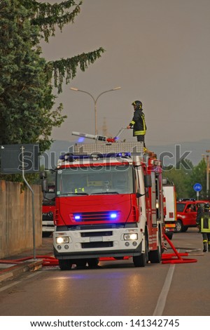 firefighters with the fire truck when switching off a fire in a factory