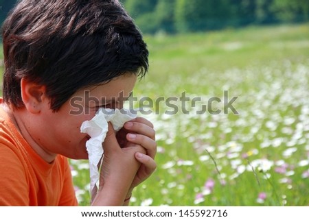 child with an allergy to pollen while you blow your nose with a white handkerchief