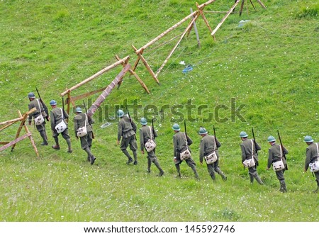 platoon of soldiers in uniform while crossing the line of enemy defense on the lawn in the mountains