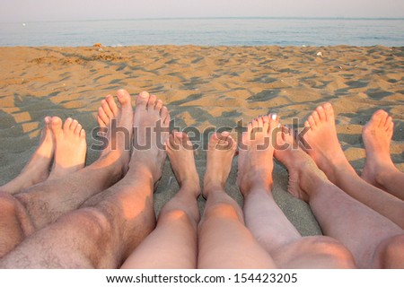 many barefoot of a family on the shore of the sea on the beach with children and parents 2