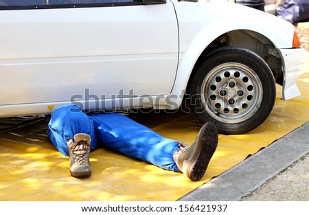 skilled mechanic with the suit from work while repairing the engine failure of the car