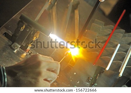gas torch lit while blending and shaping a piece of glass 1