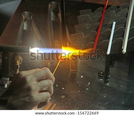 Glazier with gas torch lit while blending glass