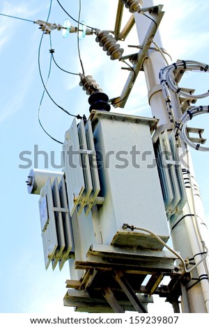 electricity transformer mounted on a tall pole outdoors
