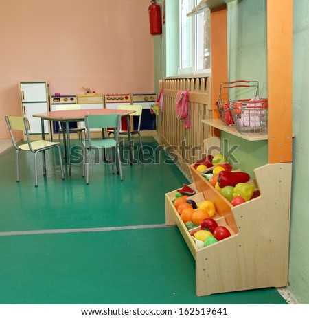 Salon of a nursery with stand of fruit and wooden kitchen toy