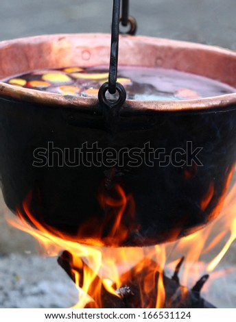 huge copper cauldron with the tasty mulled wine cooked over the open fire