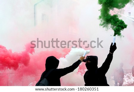 ultras fans with smoke red white and green dressed in black during a riot in the street