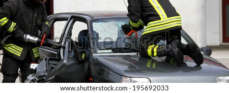 firefighters in action while they open the car after the accident to rescue the wounded