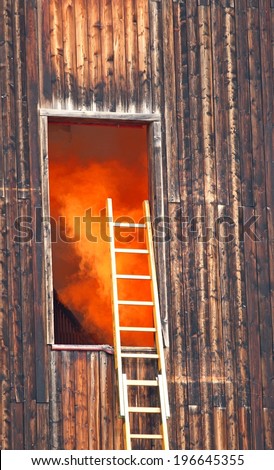 dangerous Orange smoke escapes from a wooden house during the fire and the scale of the fire brigade
