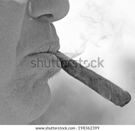 vicious smoker with the cigar in his mouth and very white smoke