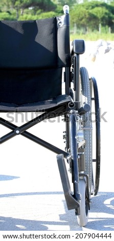 half wheelchair with Mediterranean vegetation in the background