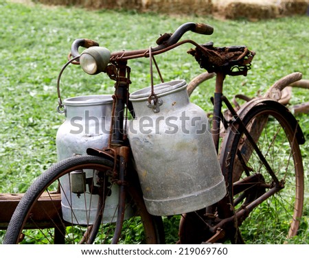 very rusty old bike of the milkman with two old milk cans and broken saddle