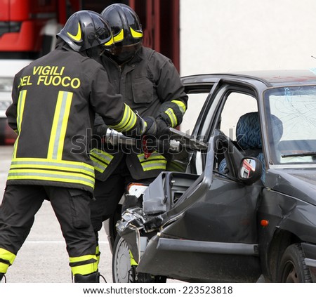 firemen open the door of the car with a powerful pneumatic shears