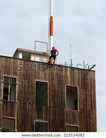 Firefighter climbing expert during the ascent abseiling from a building
