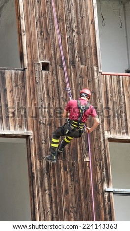 Firefighter climbing expert during the ascent abseiling from a building