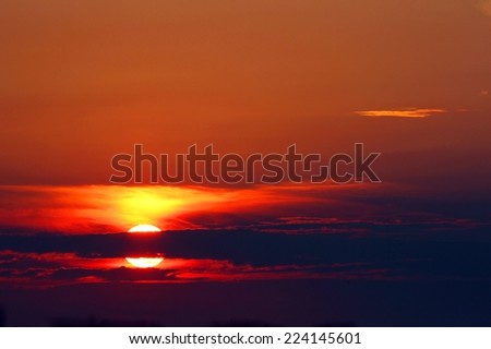 fabulous sunrise on the sea with large red Sun and reflections on ocean waves