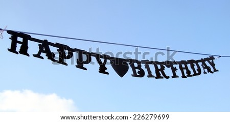 huge HAPPY BIRTHDAY sign hung on the blue sky