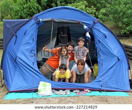 happy family of five in the blue tent camping